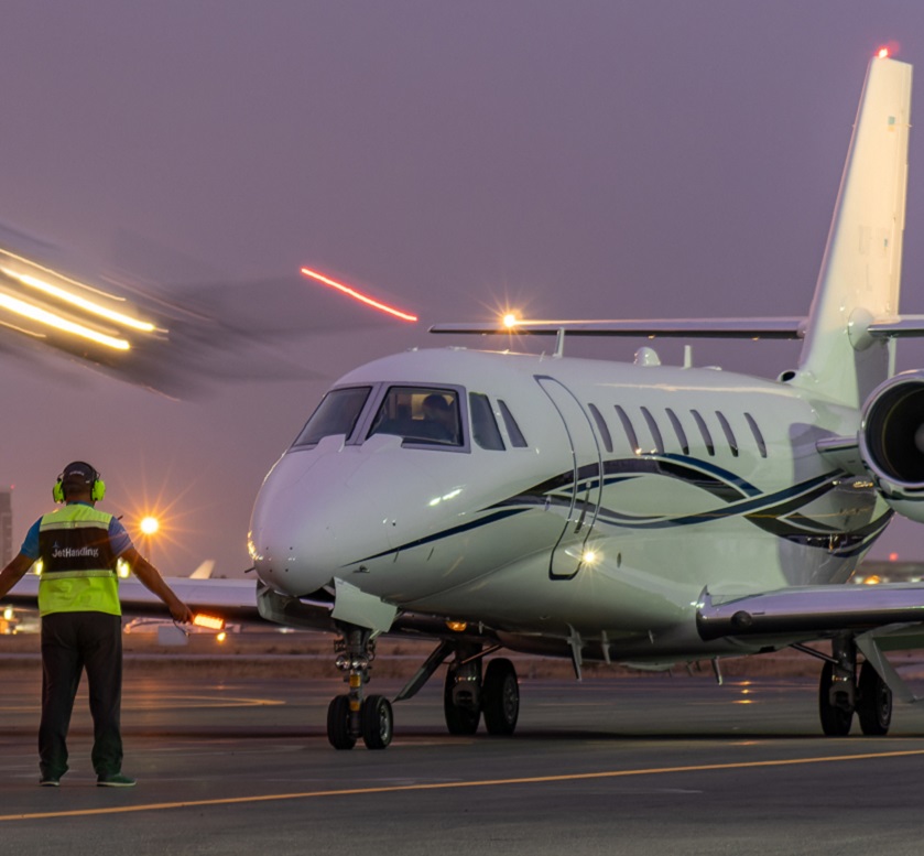 Ground handling crew signaling a private jet for landing at the airport