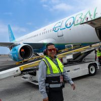 Airport ground staff loading cargo into private aircraft using forklift equipment