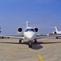 Three private jets parked on the airport runway during corporate aviation operations